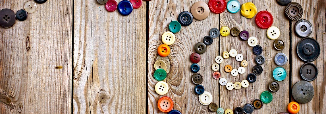 Lots of colorful buttons for clothes on wooden background Stock